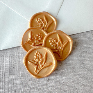 This is a gold wax seals by Maria Ferrer G. called yellow gold lily of the valley 3d wax seal stickers | set of 10 in standard