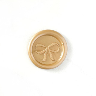 This is a gold wax seals by Abby Choi called bow wax seal in prosecco pack of 10 in standard