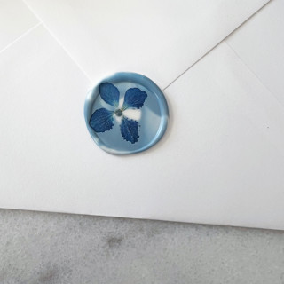 This is a blue wax seals by Caitlin Home called blue hydrangea in dusty blue marble wax seal | pack of 10 in standard