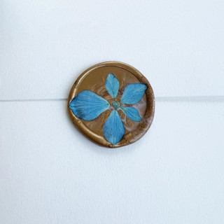 This is a blue wax seals by Caitlin Home called blue hydrangea wax seal in gold | pack of 10 in standard