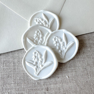 This is a white wax seals by Maria Ferrer G. called white lily of the valley 3d wax seal stickers | set of 10 in standard