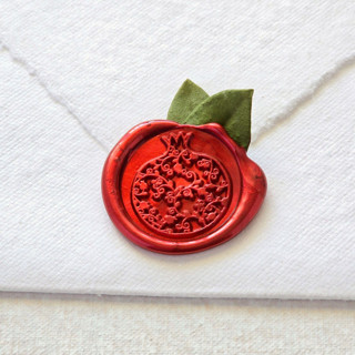 This is a red wax seals by Inkspiringletters called pomegranate with dried botanicals- hand-crafted wax seals- set of 25 in standard