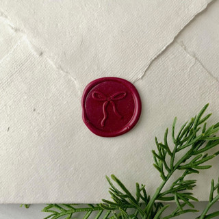 This is a red wax seals by Honey Silks Co called burgundy holiday bow wax seal - set of 10 in standard