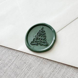 This is a green wax seals by Maria Ferrer G. called olive green "merry christmas" tree calligraphy wax seal sticker | set of 10 in standard