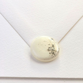 This is a white wax seals by Inkspiringletters called natural pearl white hand-crafted wax seals with gold/silver leaf- set of 25 in standard