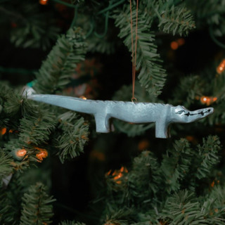 This is a green holiday decorations by Aahlada Chennupati called painted wood alligator christmas ornament in standard