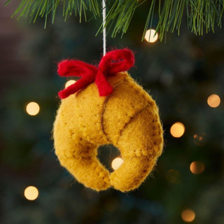 This is a brown holiday decorations by Aahlada Chennupati called felt croissant ornament in standard