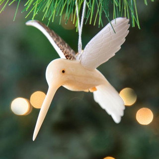 This is a beige holiday decorations by Aahlada Chennupati called mini tagua ivory humming bird ornament in standard