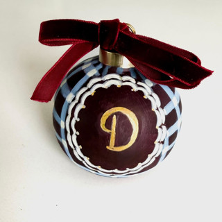 This is a brown holiday decorations by Arohika Verma called personalized hand-painted burgundy & blue plaid monogram ornament in standard