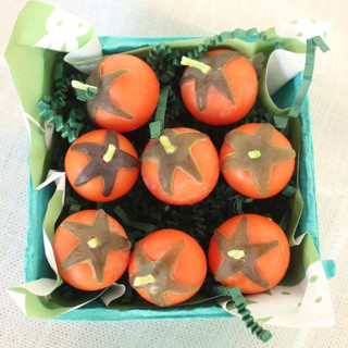 This is a orange party decorations by Happy Organics called orange cherry tomato beeswax birthday candles in standard