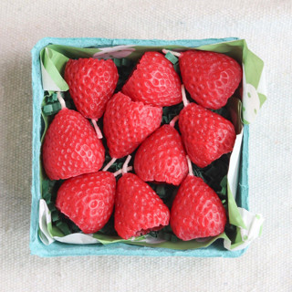 This is a red party decorations by Happy Organics called strawberry beeswax birthday candles in standard