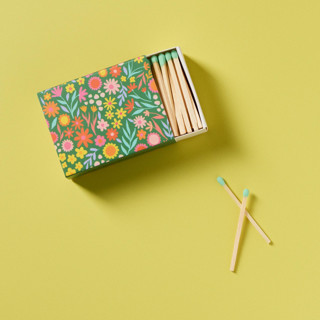 This is a green party favors by Summer Hedglin called floral meadow matchbox with colorful matchsticks in standard
