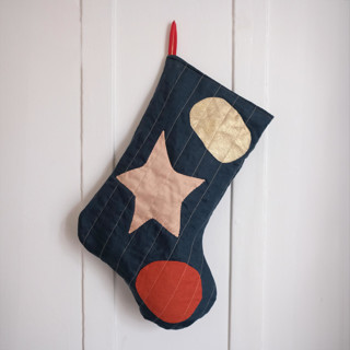 This is a green holiday decorations by Quiet Goods called green quilted stocking with multi-color appliqué details no.2 in standard