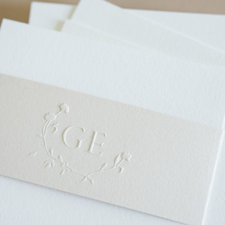 This is a silver wedding stationery by Jenny Sanders called paper embosser monogram no.13 delicate asymmetrical laurel in standard
