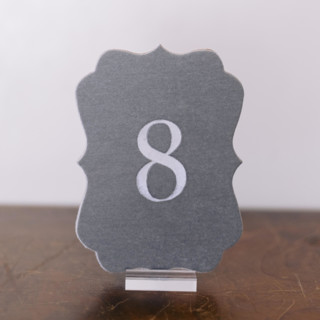This is a gray table numbers by Velvet Raptor called double sided table number - scroll - dove in standard