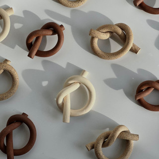 This is a multicolorassorted-colors wedding decor by Cameron Busch called custom ceramic napkin knot in standard
