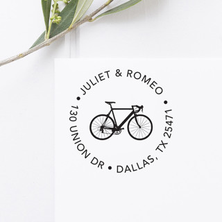 This is a black address labels by Port of Reverie called bicycle return address stamp, round self inking in standard